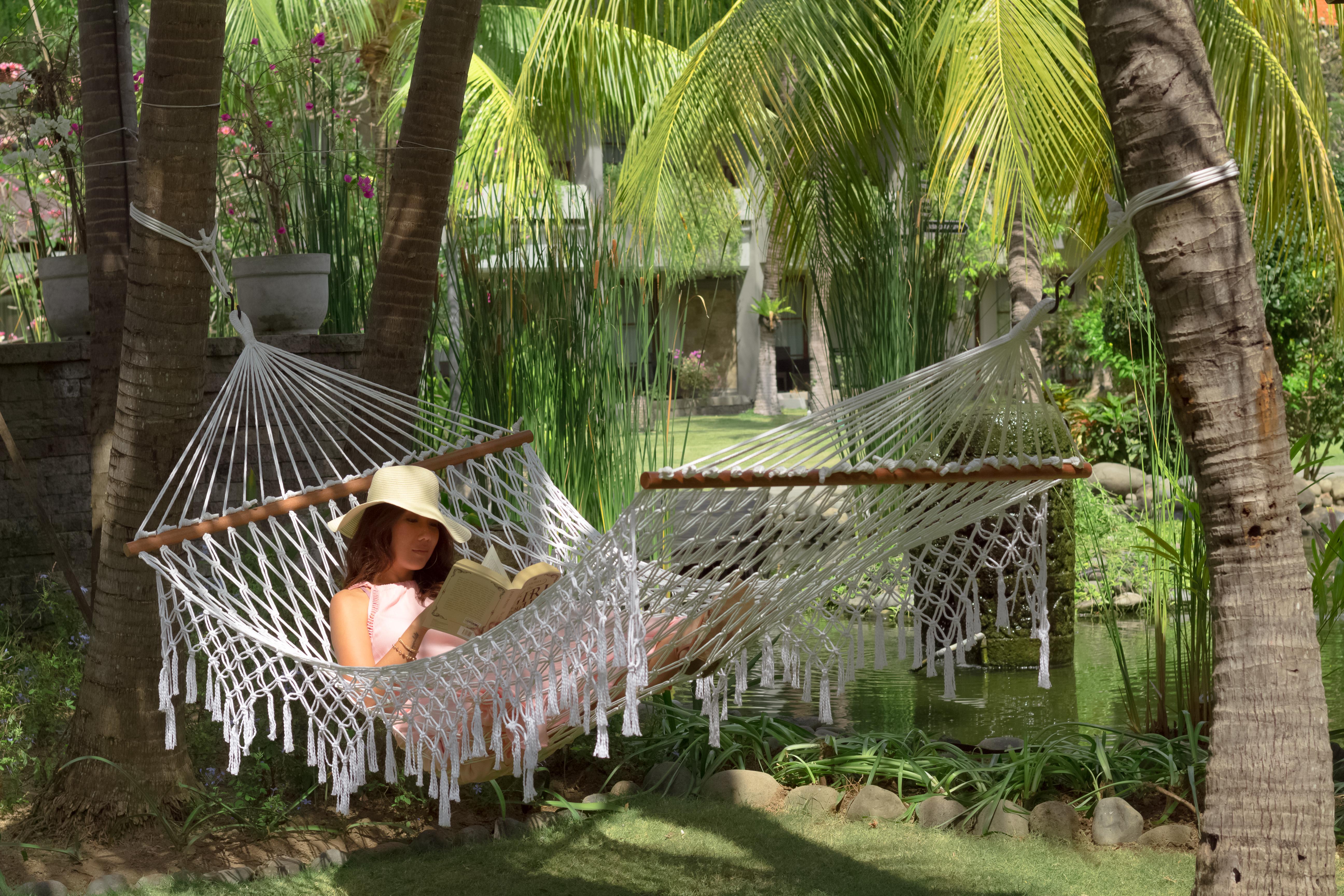 Bali Dynasty Resort Kuta Lombok Exterior foto A woman relaxing in a hammock